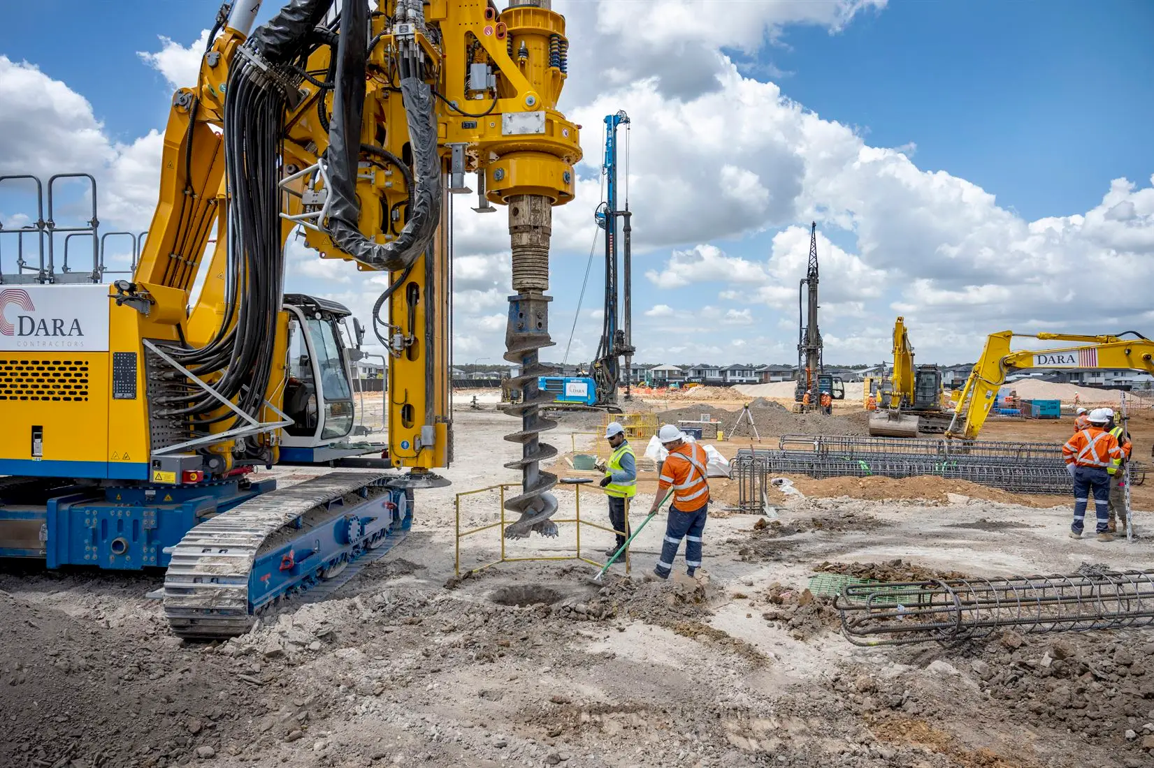 a group of men in orange vests and helmets working on a construction site